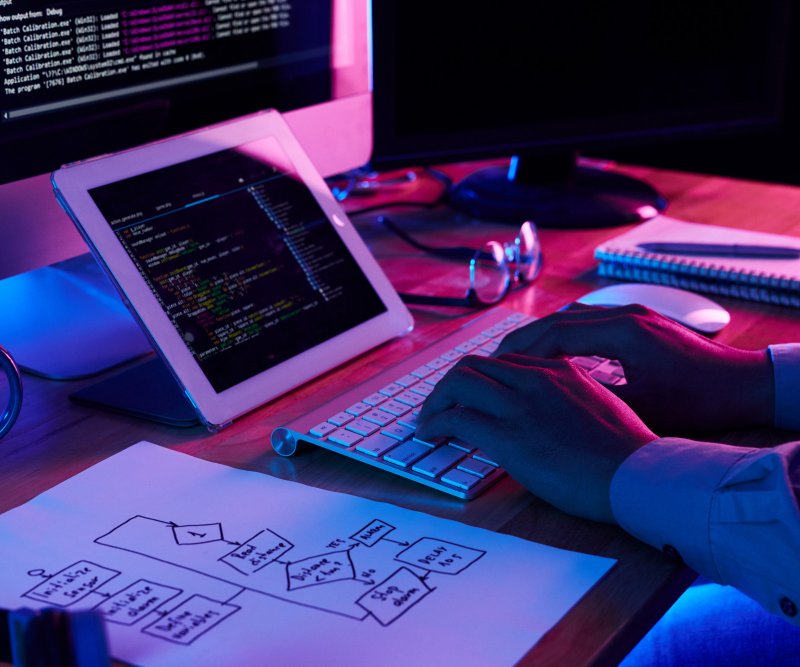 Postazione di lavoro illuminata al neon durante lo sviluppo di un sito